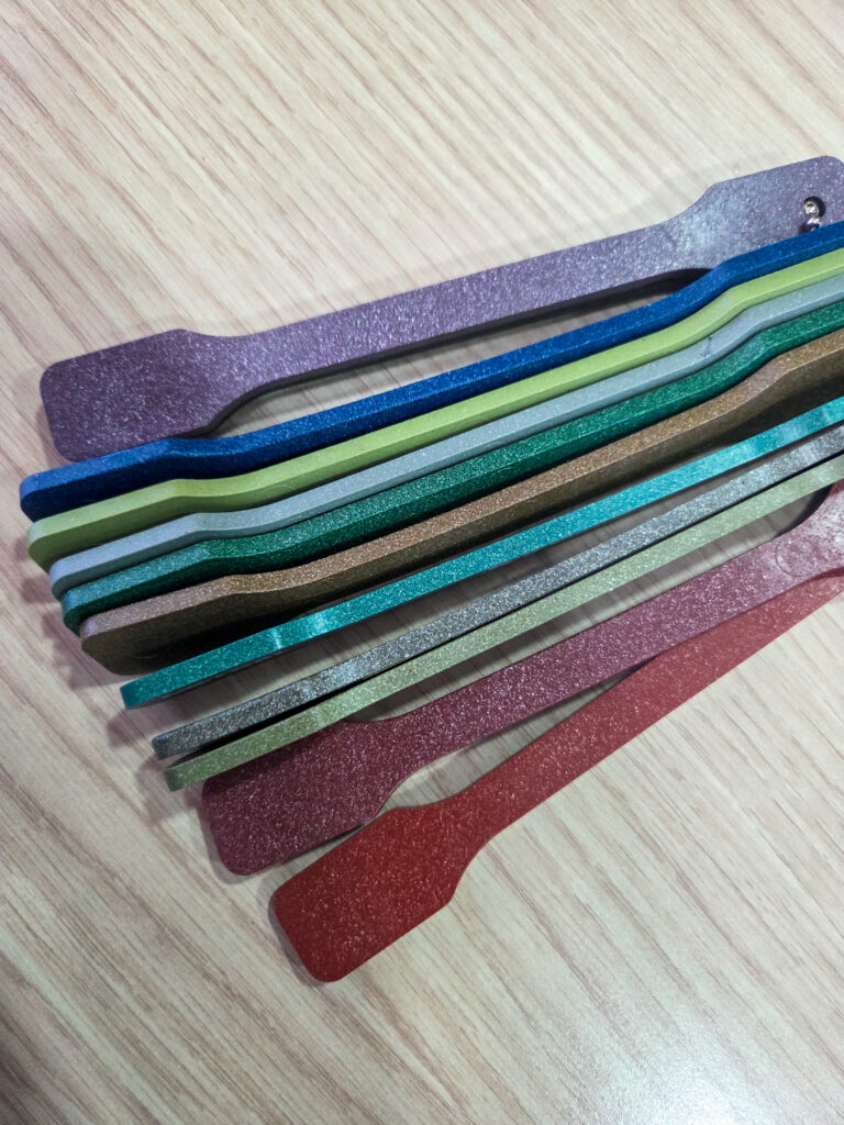Muestras de color en piezas de polyal apiladas sobre superficie de madera.